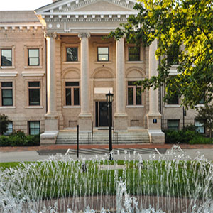 Bynum Hall, a stone building with four columns on the portico and a circular fountian in front.