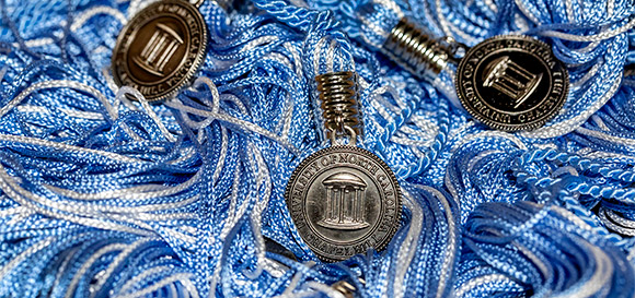 close-up of blue and white graduation tassels with Old Well medallions 